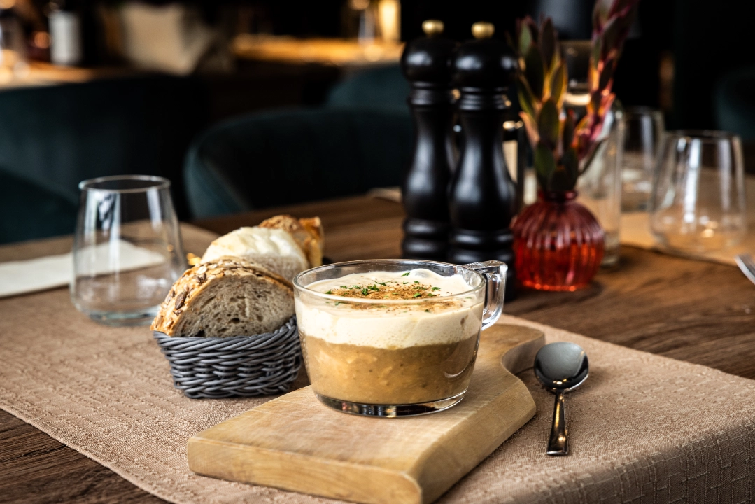 A creamy soup and a loaf of bread as a starter dish in Old Cellar Bled Restaurant.