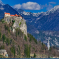 Bled Castle on a rock above lake with great mountains behind