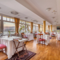 Hotel restaurant with fully set tables and view on a lake