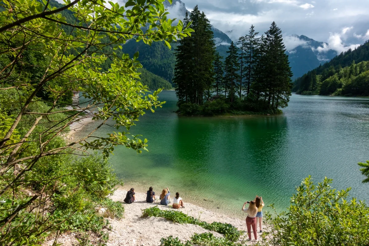 Skupina ljudi občuduje lepoto gorskega jezera