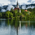 Bled Island surrounded green trees under cloudy sky