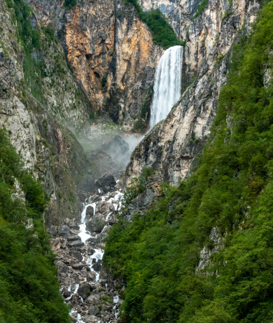 Triglav National Park Tour: Boka Waterfall, a stunning natural cascade surrounded by lush greenery and rocks.