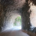 Rock tunnel with natural light shining through the far end, creating a bright circular opening.