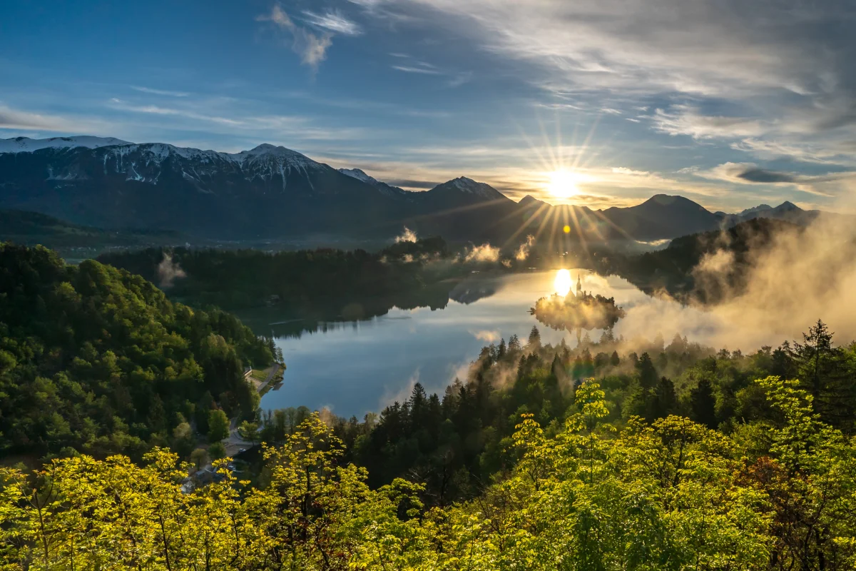 Sunrise over Lake Bled with the island partially covered by morning clouds