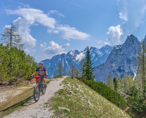 Biker on Vršič Pass with Julian Alps in the background