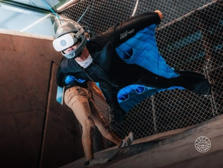 A man in a Wingsuit Flying in an Indoor Wind Tunnel Wearing AR set