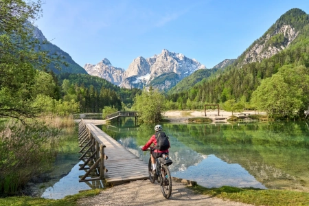 A man Cycling over a bridge near Jasna Lake in Slovenia